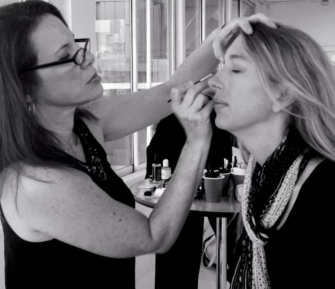 Debra applying eye makeup to a client