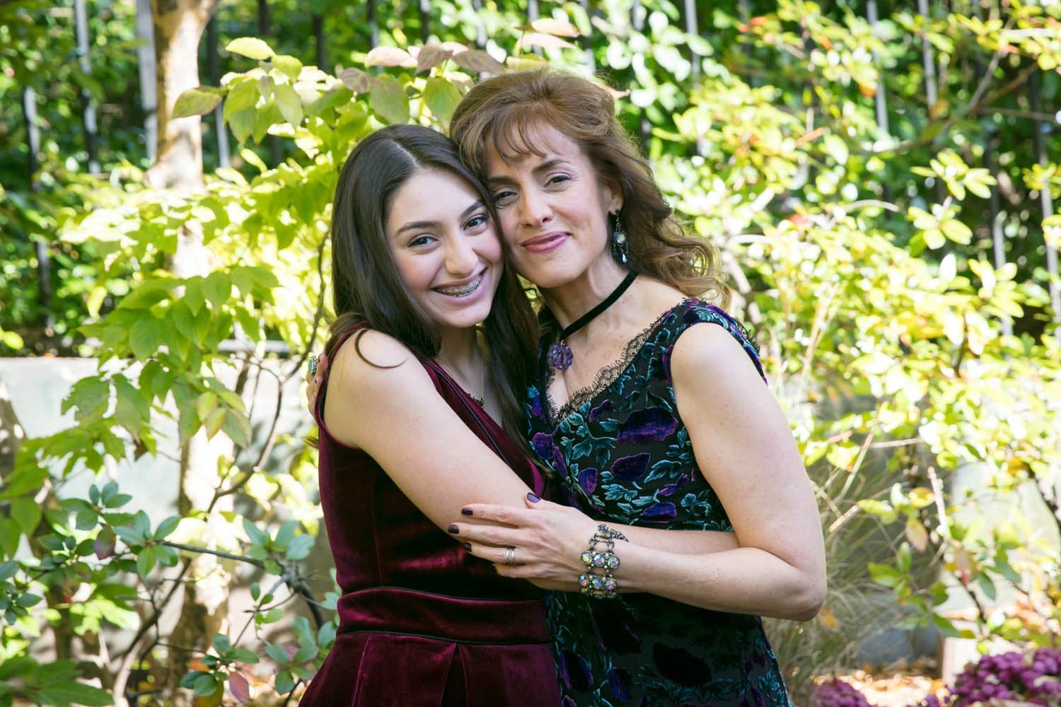 Mother and daughter hugging in a garden