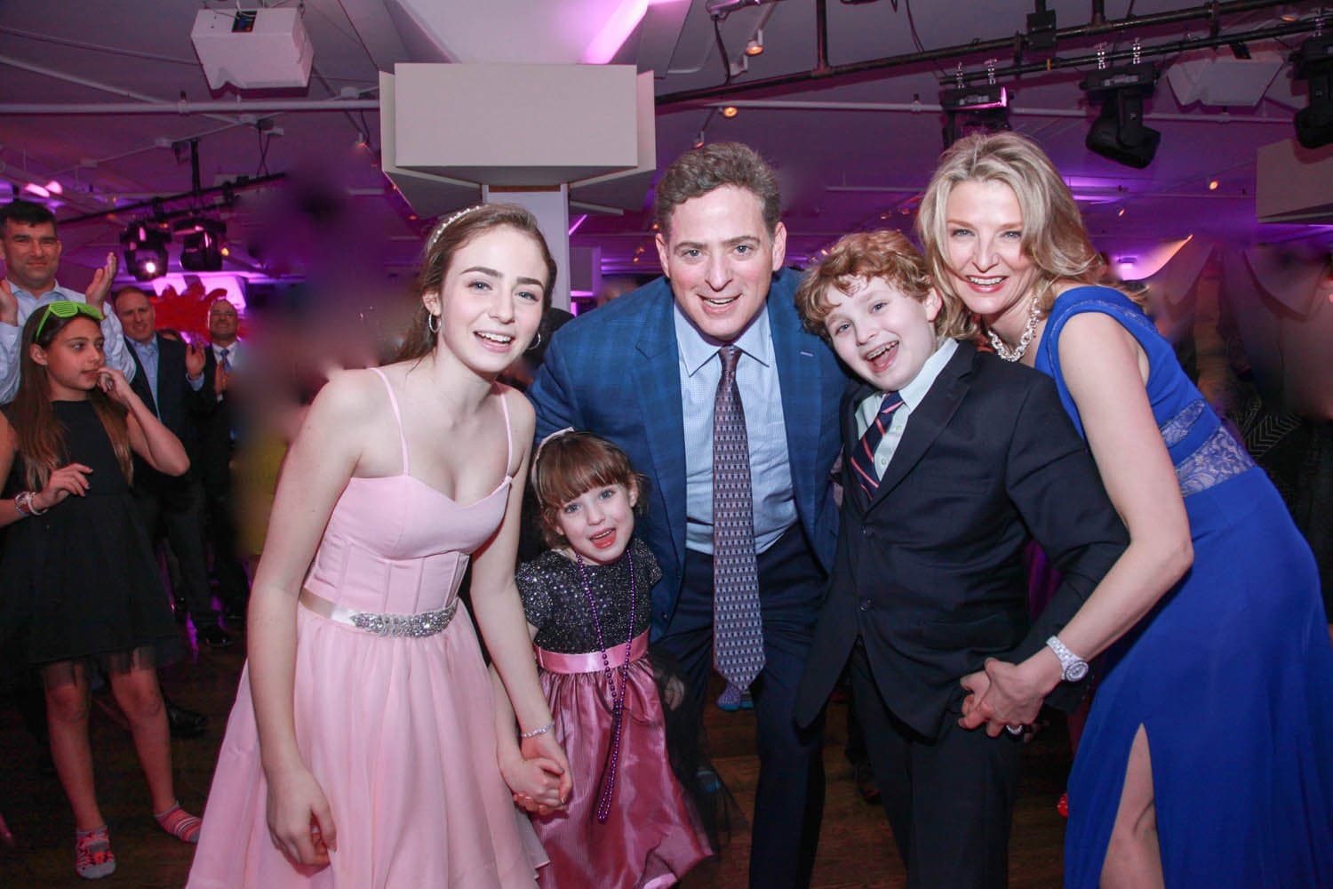 Family in party dresses and suits at a bat mitzvah party