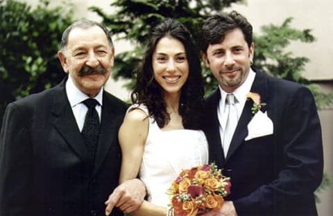 Bride standing between the groom and an older man in a suit