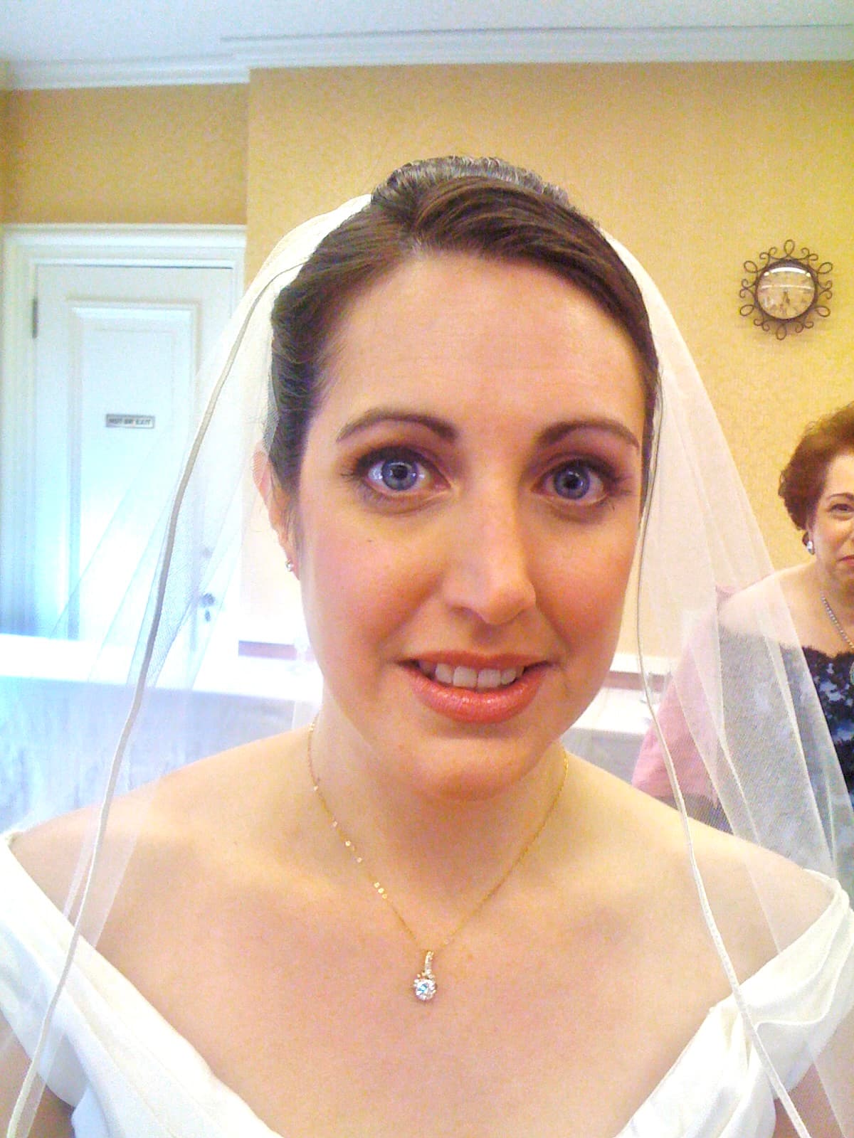 Close-up of a smiling bride in a veil and off-the-shoulder gown
